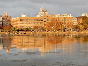 Reflection of building in lake against sky