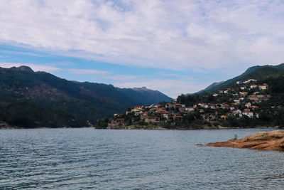 Scenic view of town by sea against sky