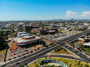 High angle view of vehicles on road by buildings against sky