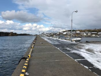 Road by lake against sky
