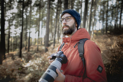 Young man looking away in forest