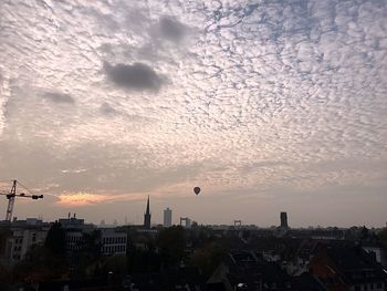 View of cityscape against cloudy sky