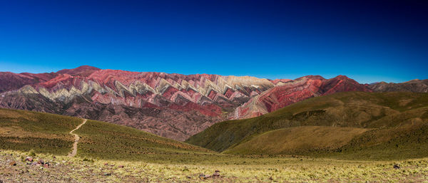 Scenic view of mountains against clear blue sky