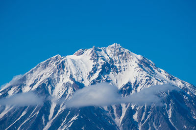 Scenic view of snowcapped mountains against clear blue sky