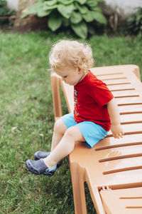 Baby boy sitting on bench