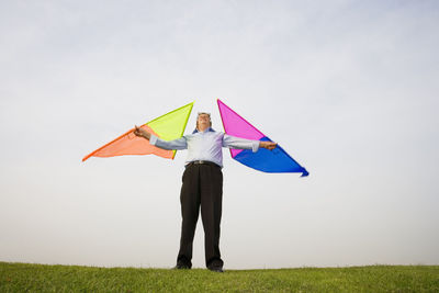 Full length of person holding umbrella on field against sky