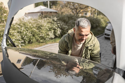 Man standing near open car boot