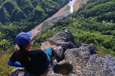 Rear view of woman on cliff looking at river