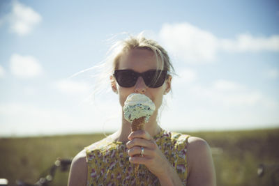Blond woman with sunglasses eating ice cream