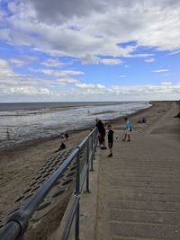 People on beach against sky