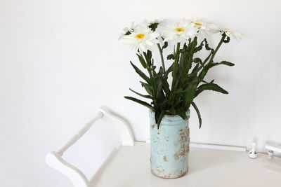 Close-up of white flower vase on table against wall