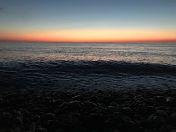 Scenic view of sea against clear sky at sunset