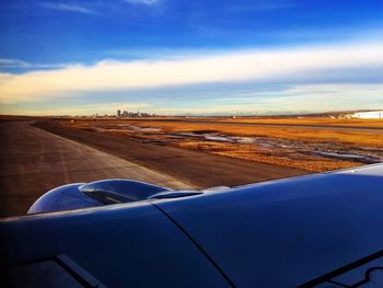 Airplane flying over landscape against sky