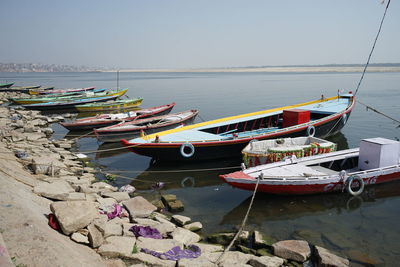 Fishing boats moored on beach against clear sky