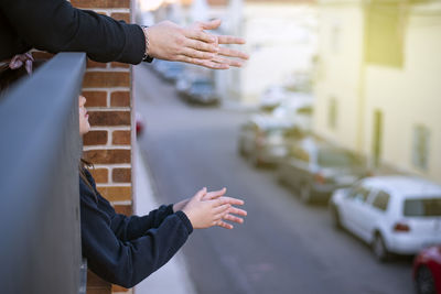 Midsection of people clapping hands in balcony