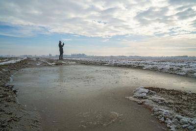 Woman standing at beach during winter