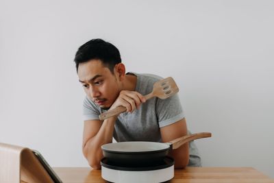 Young woman using mobile phone while sitting on table