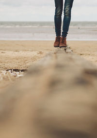 Low section of woman walking on beach