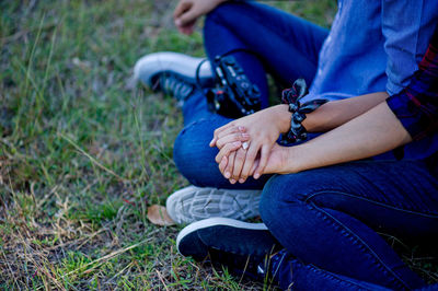 Low section of couple sitting at park