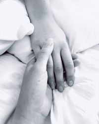 Close-up of hands on bed