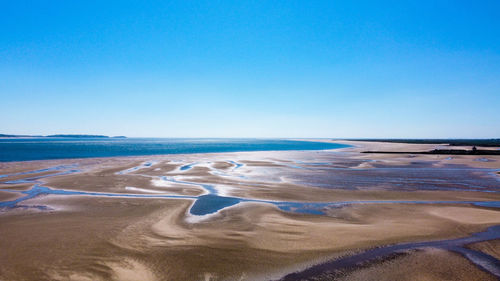 Scenic view of beach against clear blue sky