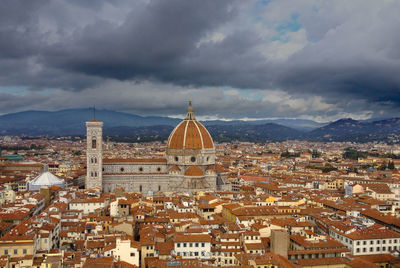 View of cityscape against cloudy sky