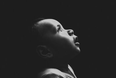 Close-up of baby girl against black background