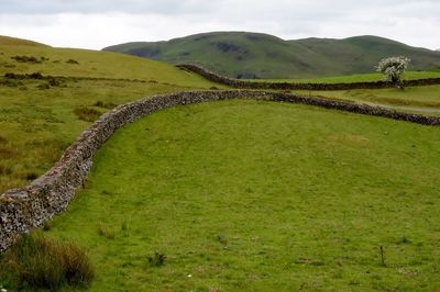 Scenic view of welsh wall and land against the sky