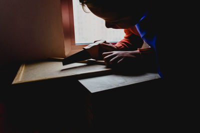 Midsection of man reading book on table