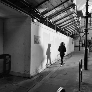 Rear view of people walking on tiled floor