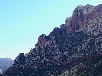 Low angle view of rocky mountain against sky