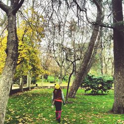 Rear view of woman walking on grass