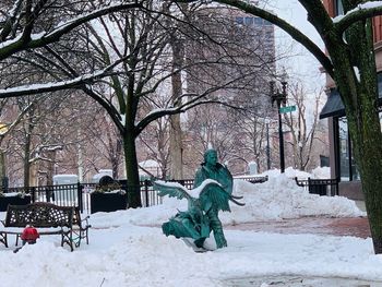 Bare trees on snow covered park during winter