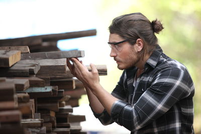 Side view of young man working on wood