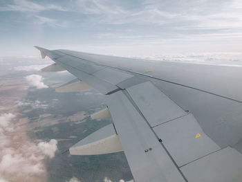 Aerial view of aircraft wing against sky