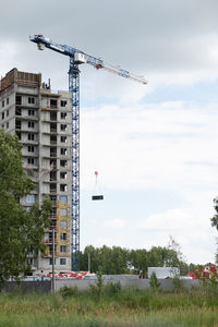 Crane on field against sky