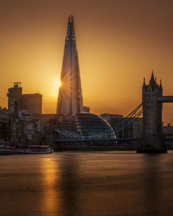 View of buildings at waterfront during sunset