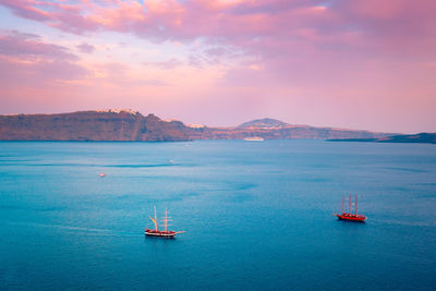 Schooner vessel ship boat in aegean sea near santorini island with tourists goes to sunset viewpoint