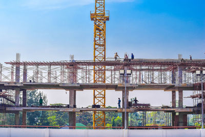 Low angle view of crane against sky