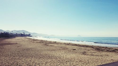 View of calm beach against clear sky