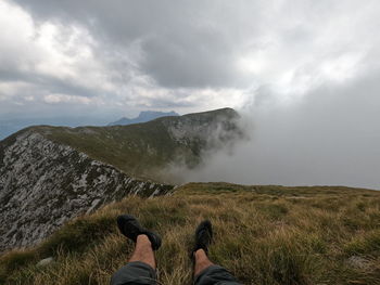 Low section of man on land against sky