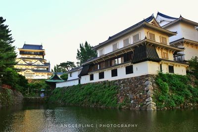 Building by river against sky