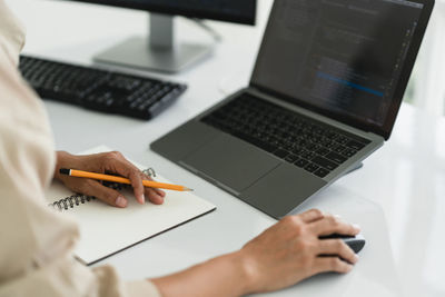 Midsection of woman using laptop