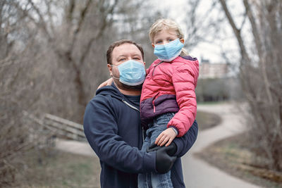 Father carrying daughter during winter on street