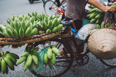 Low section of man carrying bananas on bicycle