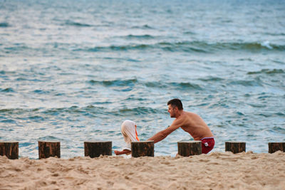 Full length of shirtless man on beach