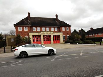 Car on road by building against sky