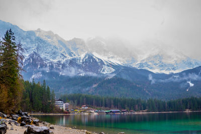 Scenic view of lake by mountains against sky