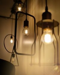 Low angle view of illuminated pendant light hanging from ceiling