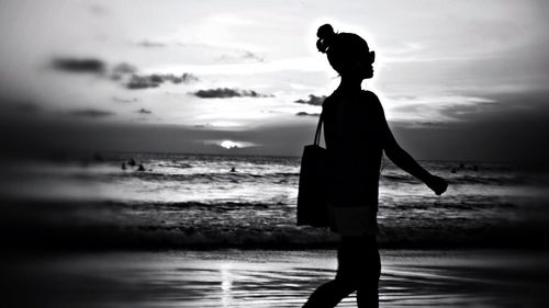 Silhouette of people on beach at sunset